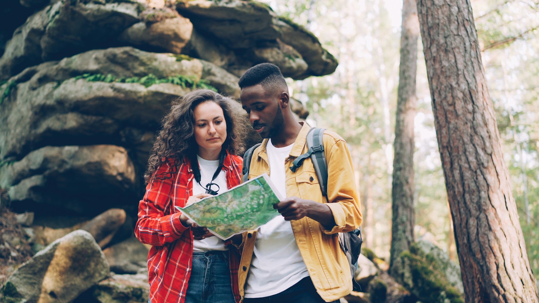 A diverse group of hikers reviewing a trail map together outdoors